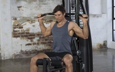 a man sitting on top of a gym machine