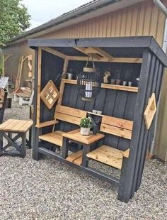 a black shed with wooden benches and tables