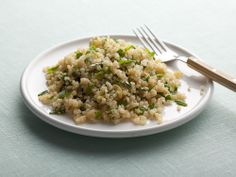 a white plate topped with rice next to a fork