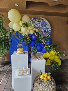 there are some yellow and white balloons on the table next to boxes with cakes in them