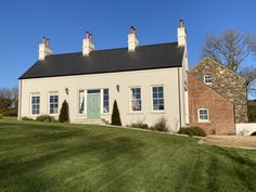 a large white house with three chimneys on top of it's roof and windows