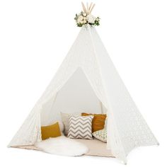 a white teepee with pillows and flowers on it, sitting in front of a white wall