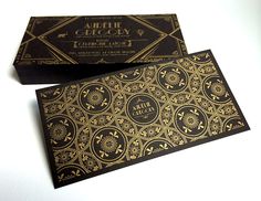 two black and gold business cards sitting on top of each other