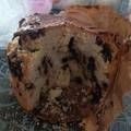 a piece of chocolate chip cake sitting on top of a table next to a cup