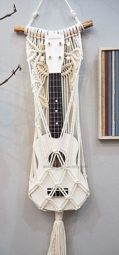 a white guitar hanging from the side of a wall