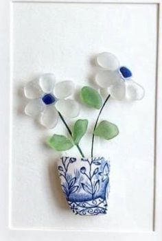 there is a blue and white vase with flowers in it on the doorknob