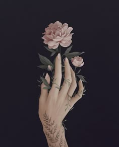 a woman's hand with tattoos holding a flower