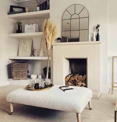 a living room filled with furniture and a fire place in front of a white fireplace