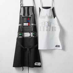 two aprons are hanging on the wall, one has a darth vader design