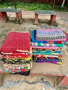 a pile of cloth sitting on top of a stone bench