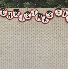 christmas eve banner hanging on a wall with pine branches and ornaments in the shape of baubles