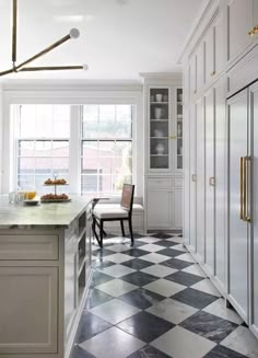 a kitchen with white cabinets and black and white checkerboard flooring on the walls