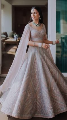 a woman in a white and gold gown is standing on the porch with her arms outstretched