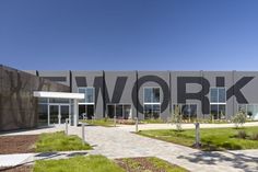 an office building with the word work painted on it's front wall and walkway