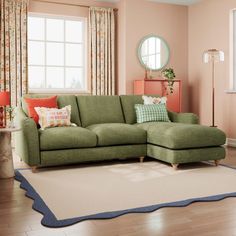 a living room with a green couch and rug on the floor in front of a window