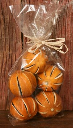 a bag filled with oranges sitting on top of a wooden table