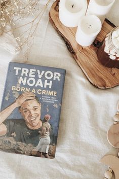 a book sitting on top of a bed next to candles and other items in front of it