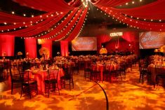 a banquet hall decorated with red drapes and lights