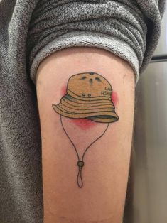 a woman's arm with a tattoo on it that has a hat on it