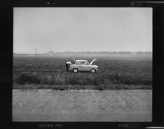 an old car parked in the middle of a field