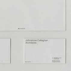 two white envelopes with some type of business card on top of them, and one in the middle