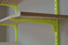 two wooden shelves are painted lime green and one shelf is made out of plywood