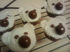 four cupcakes with white frosting and chocolate decorations