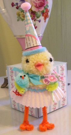 a small stuffed bird wearing a birthday hat