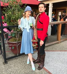 a man and woman dressed in costumes standing next to each other