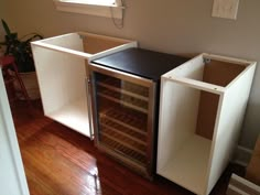 an empty wine cooler sitting on top of a hard wood floor