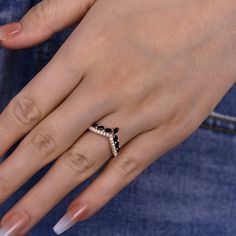 a close up of a person's hand wearing a gold ring with diamonds on it