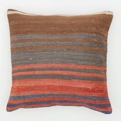 an orange, brown and blue striped pillow on a white background