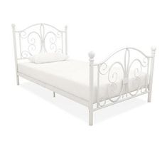 a white metal bed frame with two pillows on it's headboard and foot board