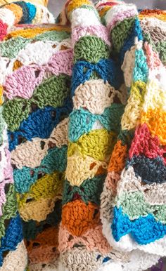 a multicolored crocheted blanket on top of a chair