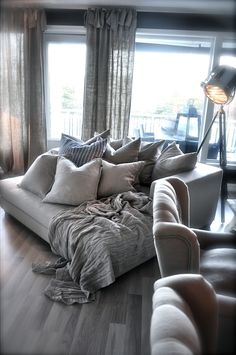 a living room filled with lots of furniture and pillows