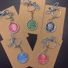 six bottle cap keychains with different sayings on them, tied to brown cards