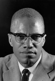 a black and white photo of a man with glasses wearing a suit, tie and eyeglasses