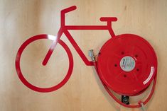 a red fire hydrant sitting on top of a wooden floor next to a bike