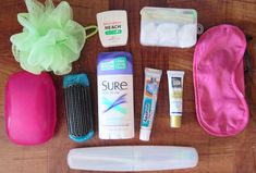 the contents of a personal care bag laid out on a wooden table, including toothpaste, soap, and other items