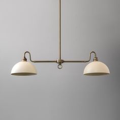 two light fixtures hanging from a ceiling fixture in an office space with gray walls and flooring