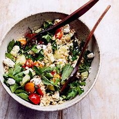 a bowl filled with salad and chopsticks sitting on top of a wooden table