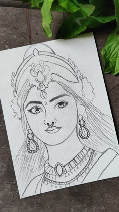 a drawing of a woman with long hair and earrings on top of a piece of paper