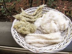 a basket filled with white wool sitting on top of a wooden bench