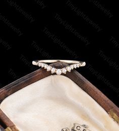 an antique diamond and pearl ring in a wooden box