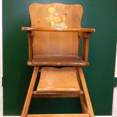 a wooden high chair with winnie the pooh on it