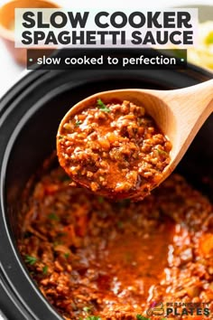 slow cooker spaghetti sauce in a crock pot with a wooden spoon scooping it out