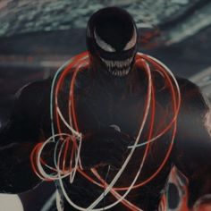 a man in a black suit with red and white wires around his neck