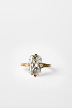 an oval cut diamond ring on a white background