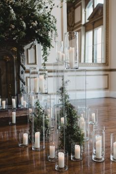 candles are arranged in clear vases on the floor