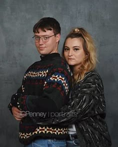 a man and woman standing next to each other with their arms around each other, posing for the camera